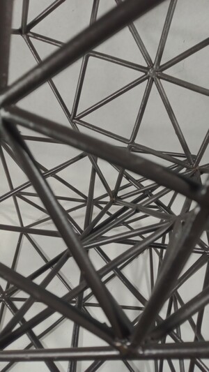 Dark gray metal grid on light grey background